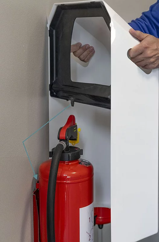 1. Wie wird die Design-Abdeckung über dem Feuerlöscher angebracht?