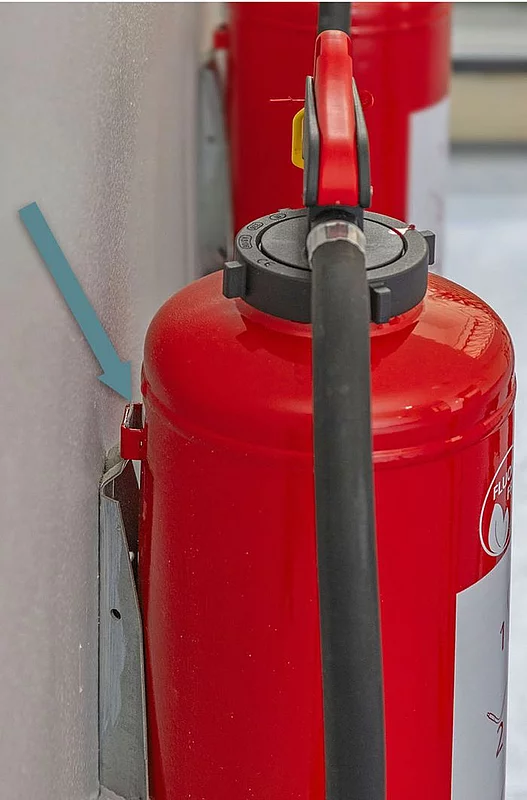 1. Wie wird die Design-Abdeckung über dem Feuerlöscher angebracht?